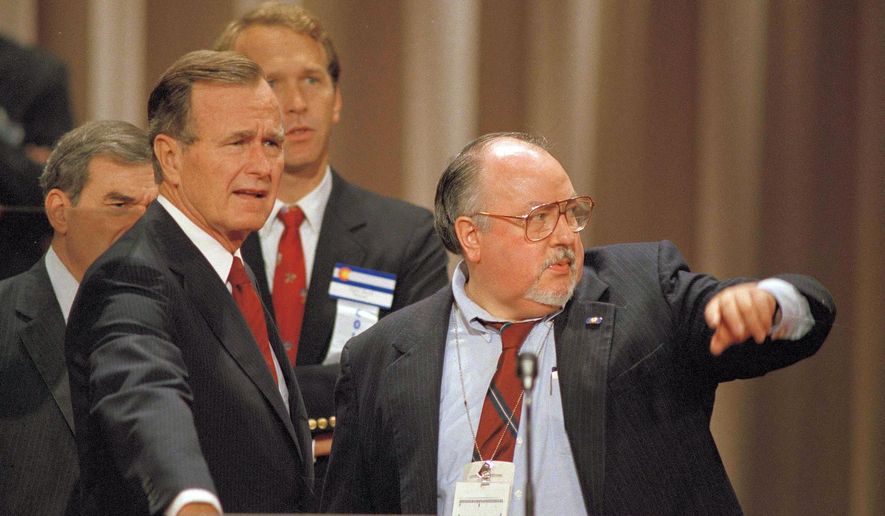 In this Aug. 17, 1988 file photo, Vice President George H.W. Bush, left, gets some advice from his media advisor, Roger Ailes, right, as they stand behind the podium at the Superdome in New Orleans, La., prior to the start